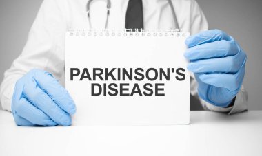 Doktorun ellerinde steteskopla Parkinson Hastalığı yazan beyaz etiket.