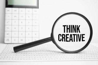 Metin içeren büyüteç Hesap makinesiyle beyaz masada yaratıcı düşünün