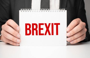 Elinde mesaj bırakan bir kağıt parçası tutan bir iş adamı.