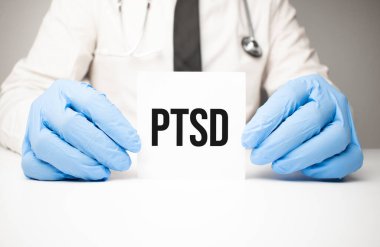 Doktorun ellerinde steteskopla TSSB mesajı olan beyaz etiket.