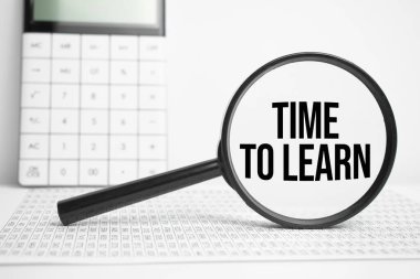 Hesap makinesiyle beyaz masada öğrenmek için metin zamanı olan büyüteç