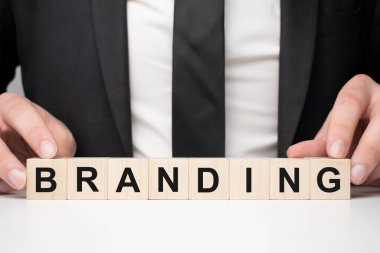 Tahta bloğu tutan bir iş adamı. İşadamı, tahta küpleri işaretli bir şekilde izliyor. Finansal. finansman