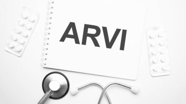 Stetoskop ve beyaz tabletlerin yanına arvi metni yazmak için tablet üzerinde.