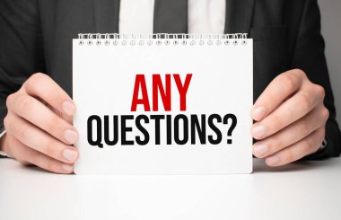 Elinde bir kâğıt tutmakta olan bir iş adamı. Herhangi bir soru.