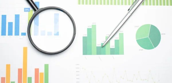 Single Magnifying Glass with Black Handle, Leaning on the financial data. Concept of Business and Finance research .