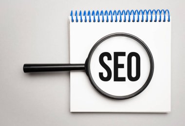 Grafik arkaplanında SEO sözcüğü olan büyüteç