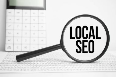 Hesap makinesi ile beyaz tablo üzerinde LOCAL SEO metin büyüteç