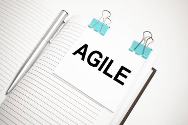 Beyaz gelecekteki hesap makinesi, kağıt çarşaf, pembe ataç ve gümüş renkli kalem. Metin çevikliği