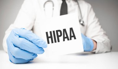 Doktorun ellerinde steteskopla hipaa metni olan beyaz etiket.