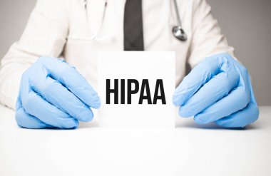 Doktorun ellerinde steteskopla hipaa metni olan beyaz etiket.