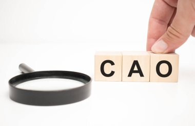 kao metin ahşap küp bloklar ve masa arka planında el ele büyüteç.