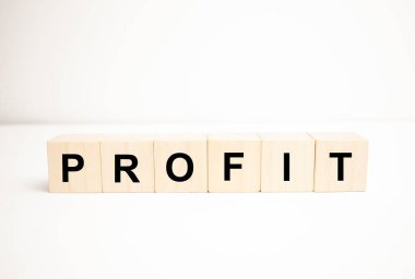 Kâr kelimesi konsepti. Tahta küpler, not defteri, kalem ve iş çizelgeleri.