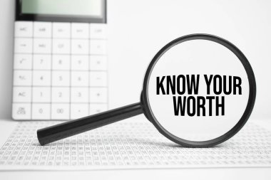 Metin içeren büyüteç Hesap makinesiyle beyaz masada Değerinizi Tanıyın