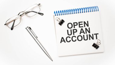 Hesap makinesi, kalem, gözlük ve bir hesap açtıran not defteri