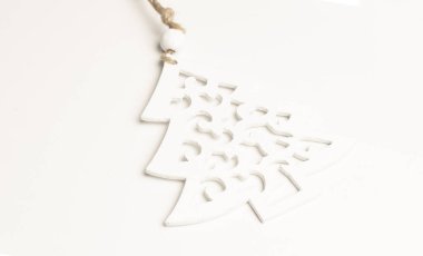 Çam ağacı beyaz boyalı ahşaptan yapılmıştır. Beyaz arka planda dur. Karda Noel ağacı kavramı..