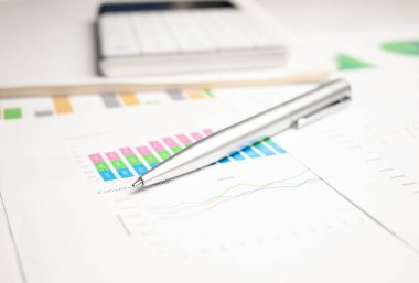 yakın plan mavi grafik ve çizelge raporları ve ofis masasında kalem, mali ve iş konsepti
