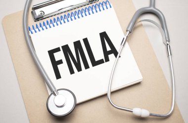 White notepad with the words fmla and a stethoscope on a blue background. Medical concept clipart