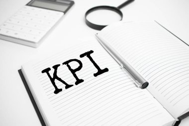 İş aksesuarları, hesap makinesi, raporlar ve KPI metin içeren büyüteç