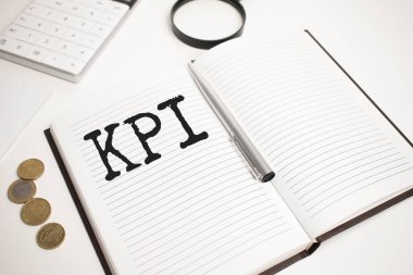 İş aksesuarları, hesap makinesi, madeni paralar, raporlar ve KPI yazılı büyüteç