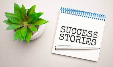 İş ahlakı, bir not panosunun, hesap makinesinin, yeşil santralin, gözlüklerin ve sarı ve beton arka planda bir kalemin yanında beyaz bir not defterine yazılmıştır. İş konsepti. Düz yatıyordu.