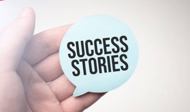 İş adamı elinde mesaj başarı hikayeleri içeren bir konuşma balonu kağıdı tutuyor.