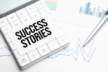 Metin başarı hikayeleri hesap makinesi, kalem ve çizelgeler, belgeler ve grafikler. Beyaz arka planda iş ve vergi kavramı. Üst görünüm.