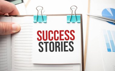 Beyaz gelecekteki hesap makinesi, kağıt çarşaf, pembe ataç ve gümüş renkli kalem. Metin başarı hikayeleri