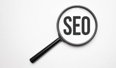 Finans ve ekonomi kavramı. Beyaz arkaplanda büyüteç, metin içinde - SEO