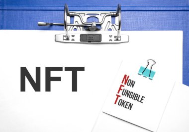 İş ve finans kavramı. Masanın üzerinde bir defter ve NFT yazılı bir klasör var.