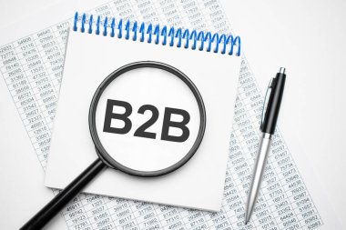 Defterde siyah kalemin yanındaki b2b metni var, büyüteç. Bir iş kavramı.