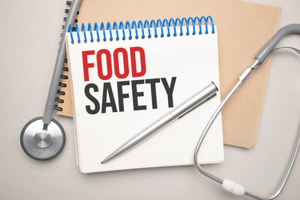 食品の安全性と青い背景に聴診器と白いメモ帳 医学的概念 — ストック写真