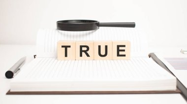 Doğru kelime konsepti. Tahta küpler, not defteri, kalem ve iş çizelgeleri.