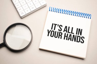 İş ve finans kavramı. Masanın üzerinde bir büyüteç, bir hesap makinesi ve üzerinde yazı olan bir defter var. Hepsi senin elinde.