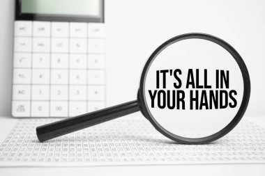 Metinli büyüteç. Hepsi hesap makineli beyaz masanın üzerinde.