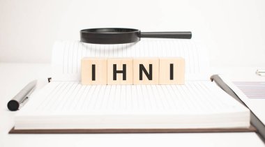 İhni kelime konsepti. Tahta küpler, not defteri, kalem ve iş çizelgeleri.