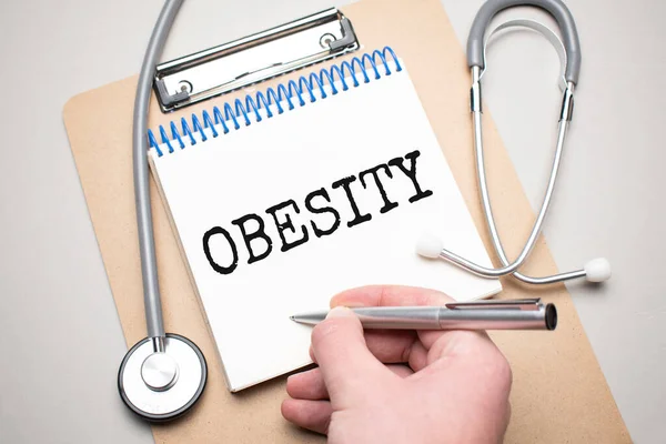 Wit Notitieblok Met Woorden Obesitas Een Stethoscoop Een Blauwe Achtergrond — Stockfoto