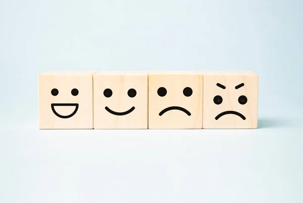Mavi arka planda gülen surat sembolü olan tahta bloklar, değerlendirme.,