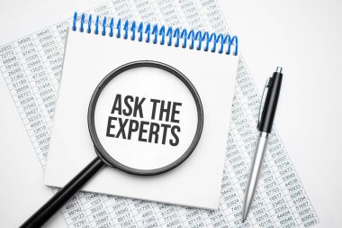 Defterde Ask the Expert 'in siyah kalemin yanında büyüteç var. Bir iş kavramı.