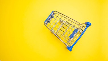 Sarı arka plandaki alışveriş arabasında fotokopi alanı var.