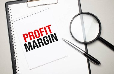 Beyaz zemin üzerinde PROFIT MARGIN yazan büyüteç