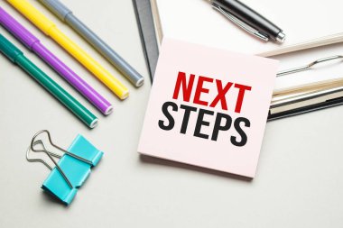 Raporlar ve renk çizelgeleri masada. Siyah çerçevede kırmızı kalemler, kalemler ve kâğıtlar vardır. Üzerinde 