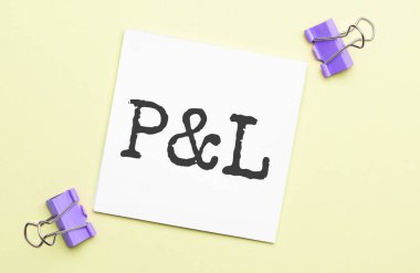 Kırtasiyeli sarı arkaplan üzerinde P ve L harfi olan beyaz kağıt