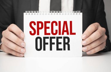 Elinde özel bir mesaj içeren kağıt tutmakta olan bir iş adamı.