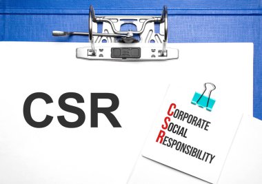 İş ve finans kavramı. Masanın üzerinde bir defter ve üzerinde CSR yazılı bir klasör var.