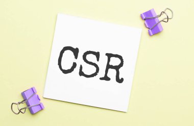 Kırtasiyeli sarı bir arka planda CSR yazılı beyaz kağıt