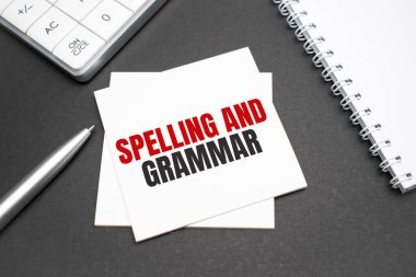 Hesap makinesi, kalem ve açık defter. Tahta arka planda Heceleme ve Gramer ile yazılmış. İş Konsepti.