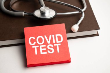 Mavi arkaplan ve steteskop ve haplarla ilgili metin covid testi içeren kağıt
