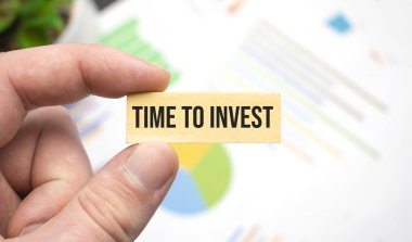 Çalışma masasına harf yatırmak için zamanı olan tahta küpü tutan elleri kırpılmış görüntü. Üst görünüm