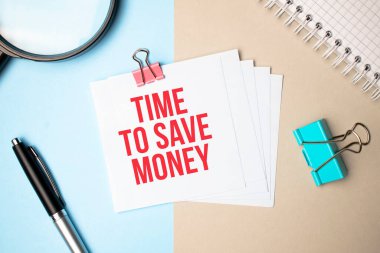 Arka planda hafif bir büyüteç, kalem ve üzerinde para biriktirmek için kullanılan bir defter. İş konsepti