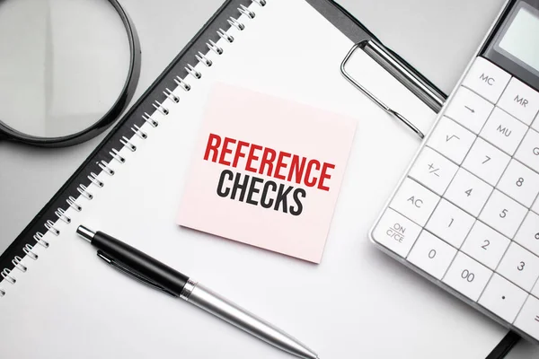 REFERENCE CHECKS. Notepad, eyeglasses and white pen. Financial concept